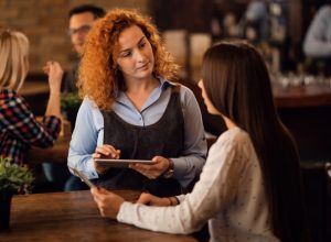 redhead-waitress-talking-woman-writing-order-digital-tablet-pub-scaled_p30366_thumb_resized.jpg
